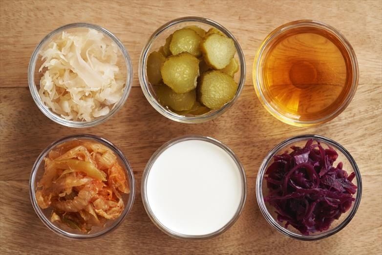 Sex skålar med fermenterad mat, bland annat kimchi, gurka och surkål